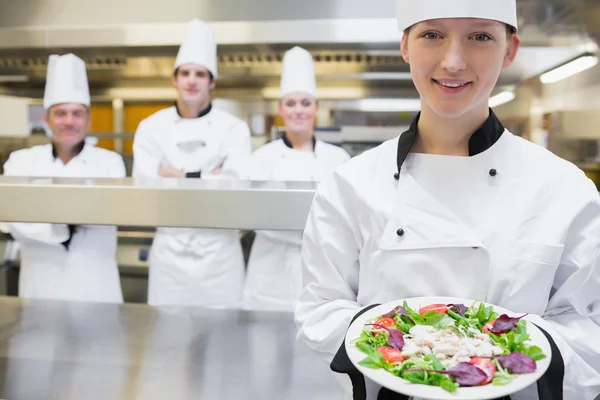 Lächelnder Koch reicht einen Salat — Stockfoto