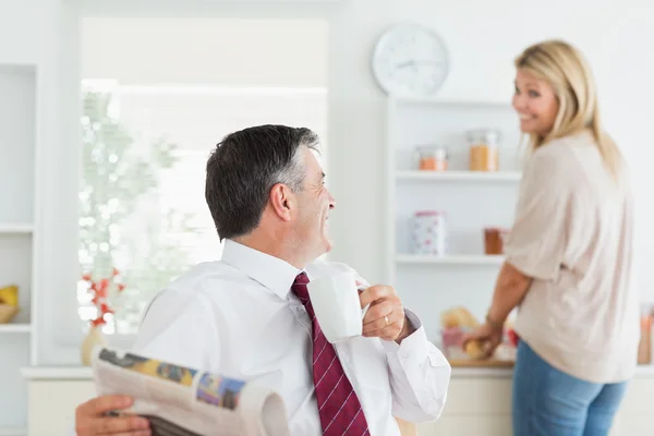 Paar lacht vor der Arbeit gemeinsam in der Küche — Stockfoto