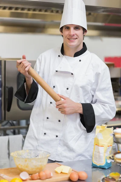 Homme souriant tenant un rouleau à pâtisserie — Photo