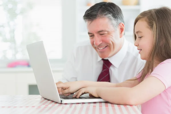 Menina digitando com o pai assistindo — Fotografia de Stock