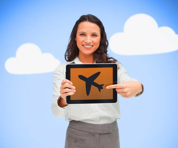 Frau steht mit Tablet-PC, der ein Flugzeug-Symbol zeigt — Stockfoto