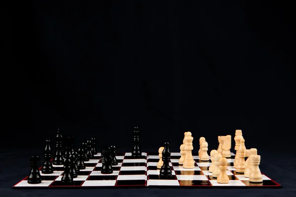 Chessboard mot svart bakgrunn – stockfoto