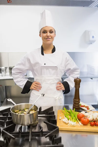 Chef sorrindo enquanto cozinha sopa — Fotografia de Stock