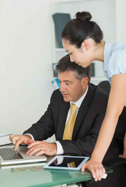 Hombre y mujer de negocios trabajando en una computadora portátil — Foto de Stock