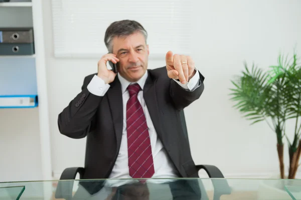 Businessman phoning and pointing — Stock Photo, Image