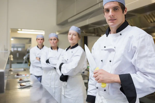 Team av kockens med en innehar en kniv — Stockfoto