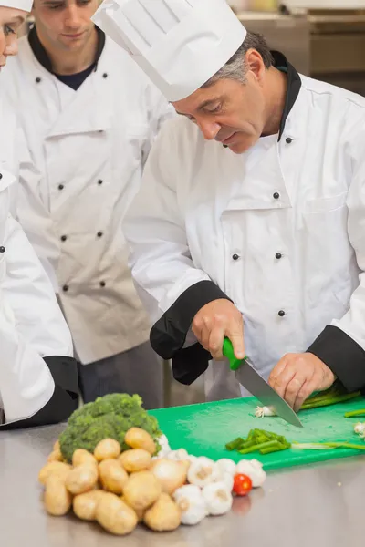 Chef grupo de ensino como cortar legumes — Fotografia de Stock