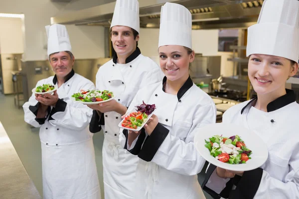 Gelukkig chef-kok de presentatie van hun salades — Stockfoto