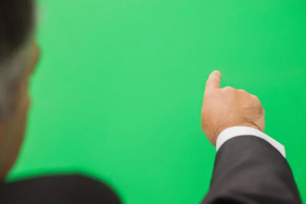 Businessman pointing to green copy space — Stock Photo, Image