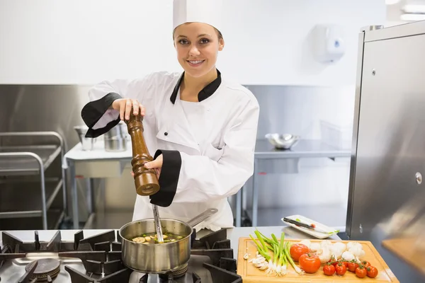 Chef spicing soup and smiling — Stock Photo, Image