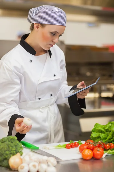 Chef consulta tableta digital antes de preparar verduras —  Fotos de Stock