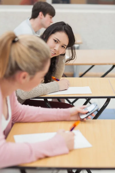 Women talking and texting during class Stock Photo