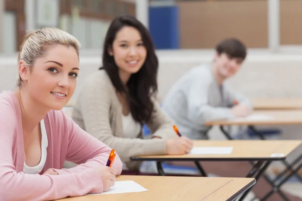 Students looking up from exam and smiling Royalty Free Stock Images