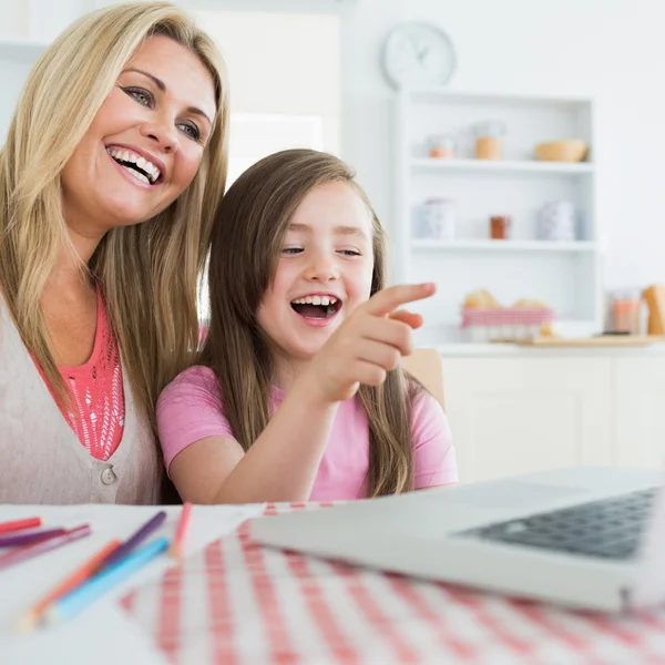 Moeder en dochter lachen om laptop — Stockfoto