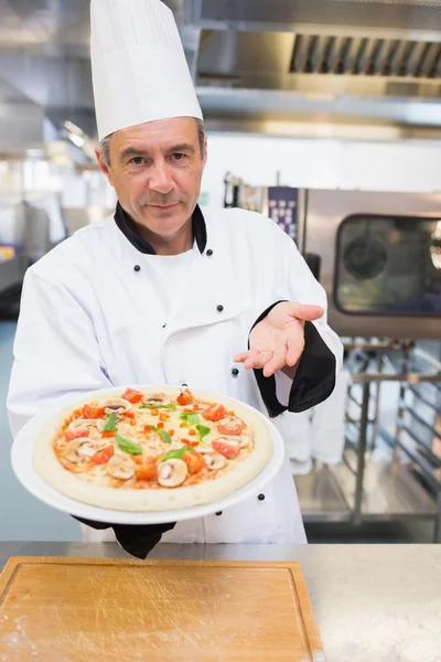 Cook presenting his pizza