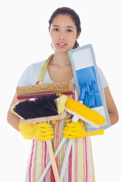 Frowning woman holding brushes and mops — Stock Photo, Image