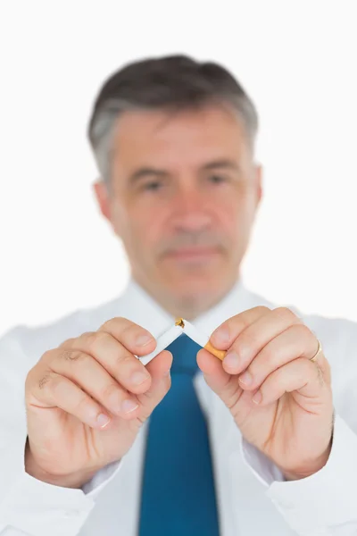 Businessman breaking a cigarette — Stock Photo, Image