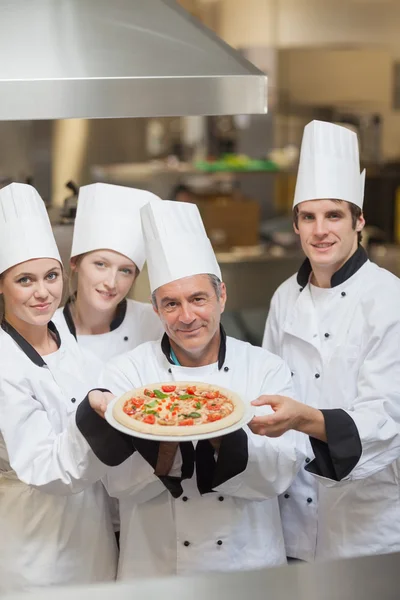 Four Chef's holding a pizza — Stock Photo, Image