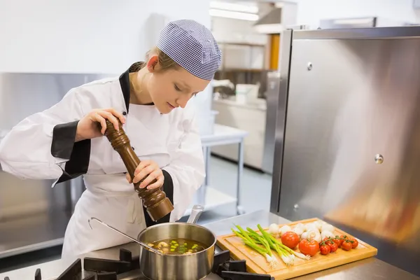 Woman spicing soup in kitchen — Stock Photo, Image