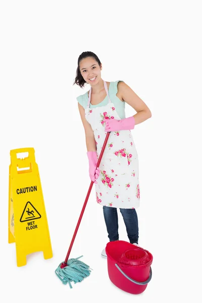 Woman cleaning near a caution sign — Stock Photo, Image