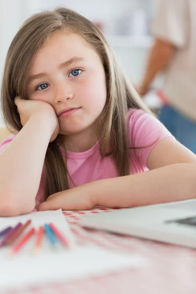 Girl sitting at kitchen looking bored — Stock Photo, Image