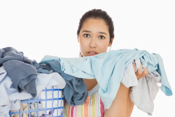 Mujer frunciendo el ceño sacando ropa sucia — Foto de Stock