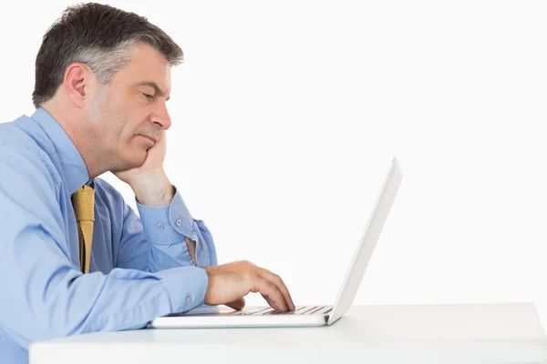 Unavený muž píše na jeho laptopu — Stock fotografie