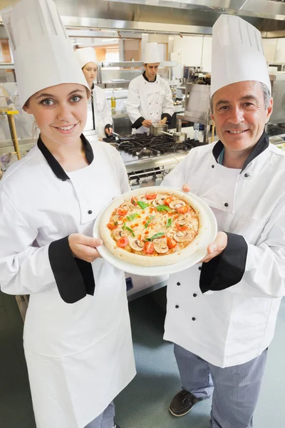 Koch präsentiert eine Pizza — Stockfoto