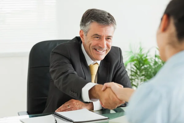 Mann schüttelt einer Frau im Büro die Hand — Stockfoto