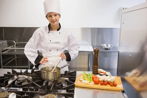 Chef standing at stove while smiling — Stock Photo, Image