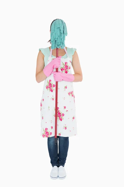 Frau in Schürze versteckt ihr Gesicht mit einem Wischmopp — Stockfoto