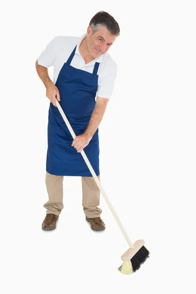 Happy man sweeping floor — Stock Photo, Image