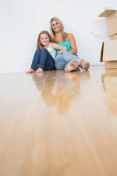 Mother and daughter sitting on the floor together — Stock Photo, Image