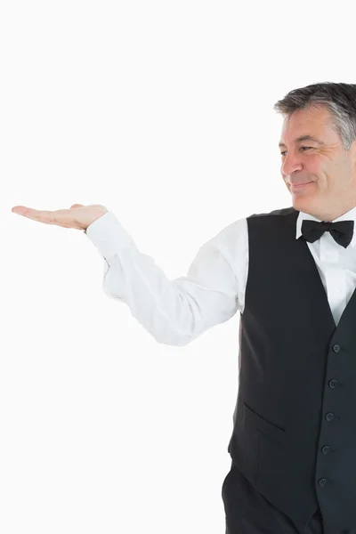 Smiling waiter holding something — Stock Photo, Image