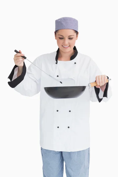 Smiling cook cooking with wok and spoon — Stock Photo, Image