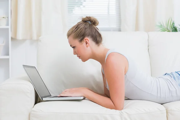 Mulher usando notebook enquanto relaxa — Fotografia de Stock