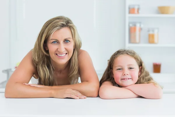 Mãe e filha se apoiando na mesa na cozinha — Fotografia de Stock