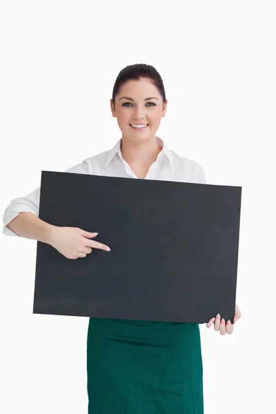 Kellnerin zeigt auf Tafel, die sie in der Hand hält — Stockfoto