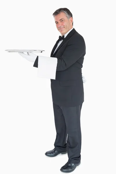 Waiter holding silver tray while is looking into the camera — Stock Photo, Image