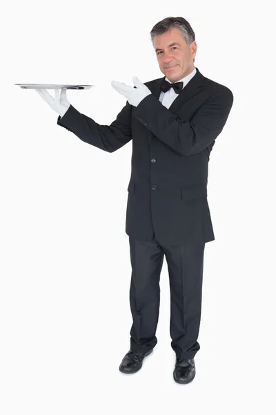 Happy waiter presenting a tray — Stock Photo, Image