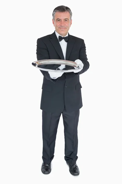 Waiter holding out empty silver tray — Stock Photo, Image