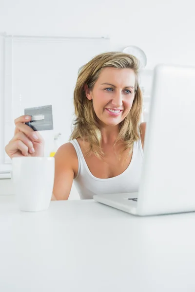 Femme souriante utilisant un ordinateur portable pour magasiner en ligne — Photo