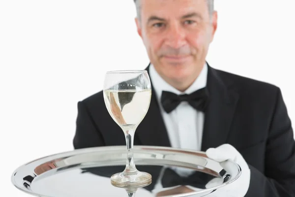 Uomo sorridente che serve un bicchiere di vino sul piatto — Foto Stock