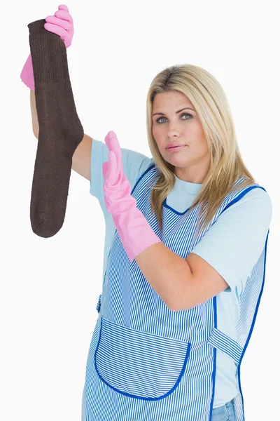 Cleaning woman holding a dirty sock — Stock Photo, Image