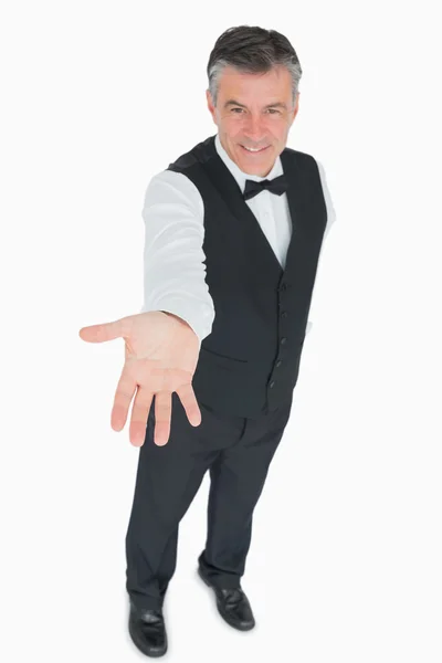 Waiter holding hand out to front — Stock Photo, Image
