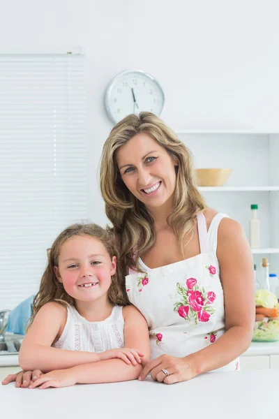 Mother and daughter leaning on table — Stock Photo, Image