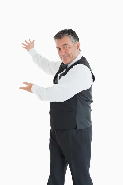 Smiling waiter showing us something — Stock Photo, Image