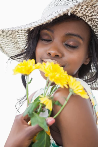 Femme sentant les fleurs jaunes — Photo