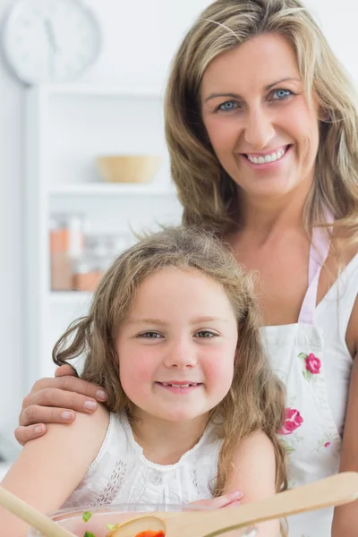 Moeder knuffelen dochter en het maken van salade — Stockfoto