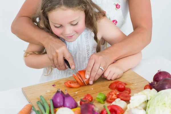 Madre ayudando a su hija a cortar tomate — Foto de Stock